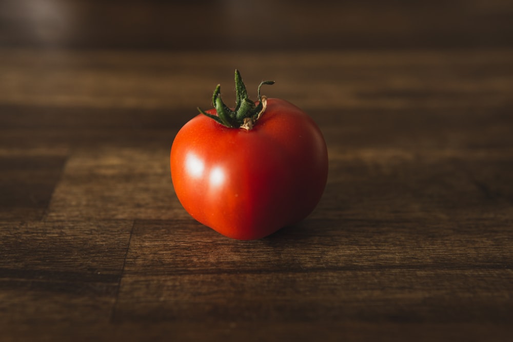 rote Tomate auf braunem Holztisch