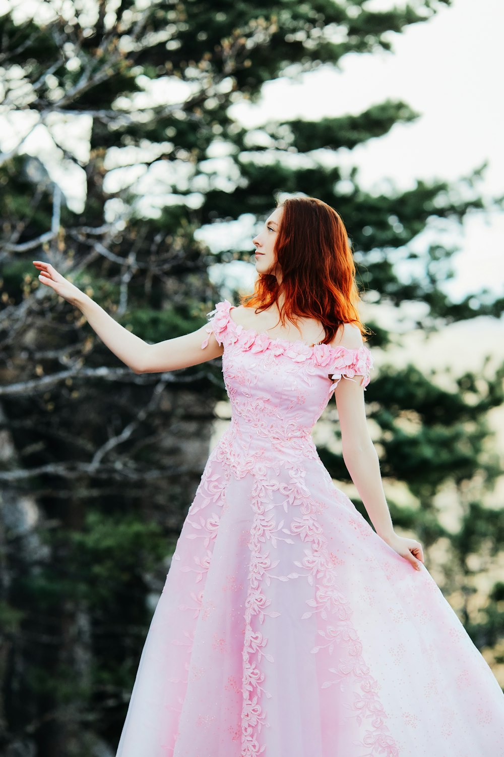 Mädchen in rosa Kleid, das tagsüber im Wald steht