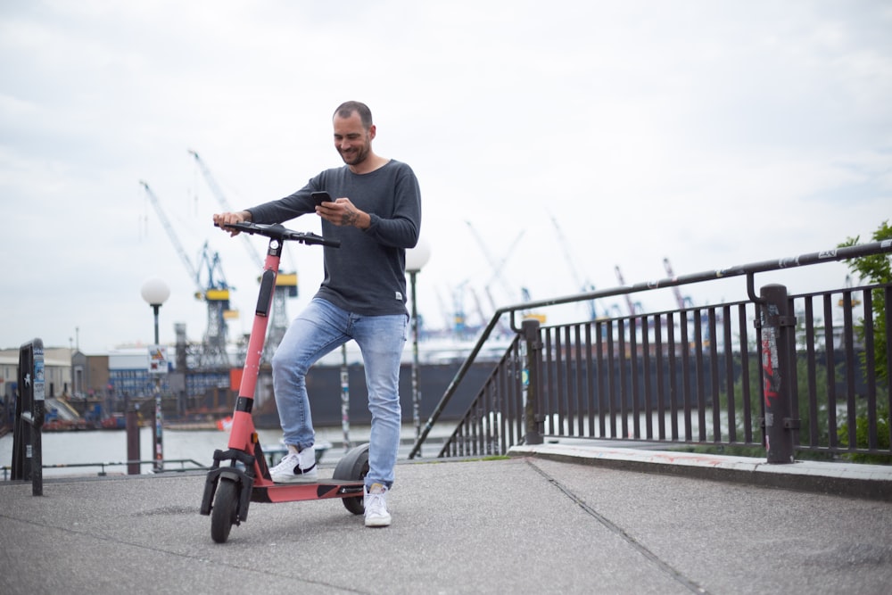 homme en chemise à manches longues noire équitation scooter rouge