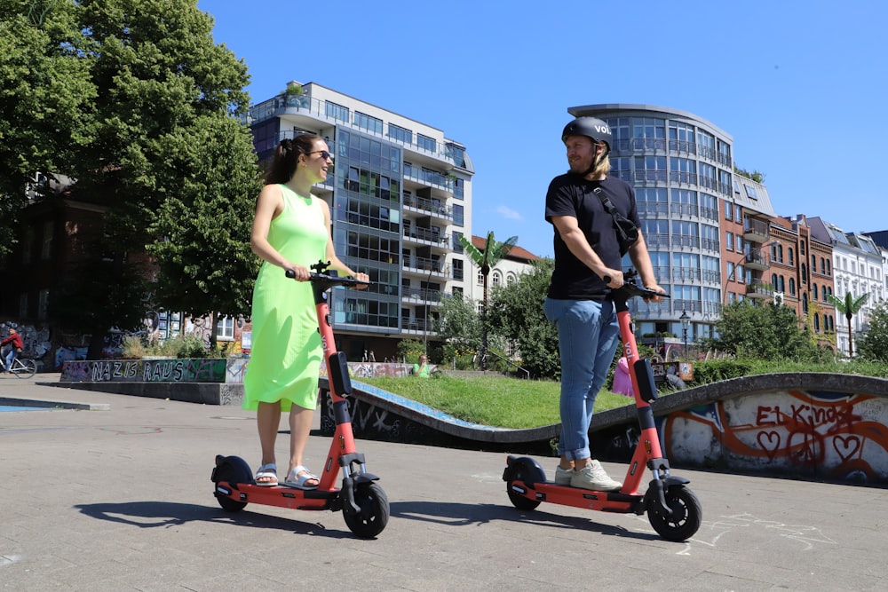 fille en robe rose équipant une trottinette rouge et noire pendant la journée