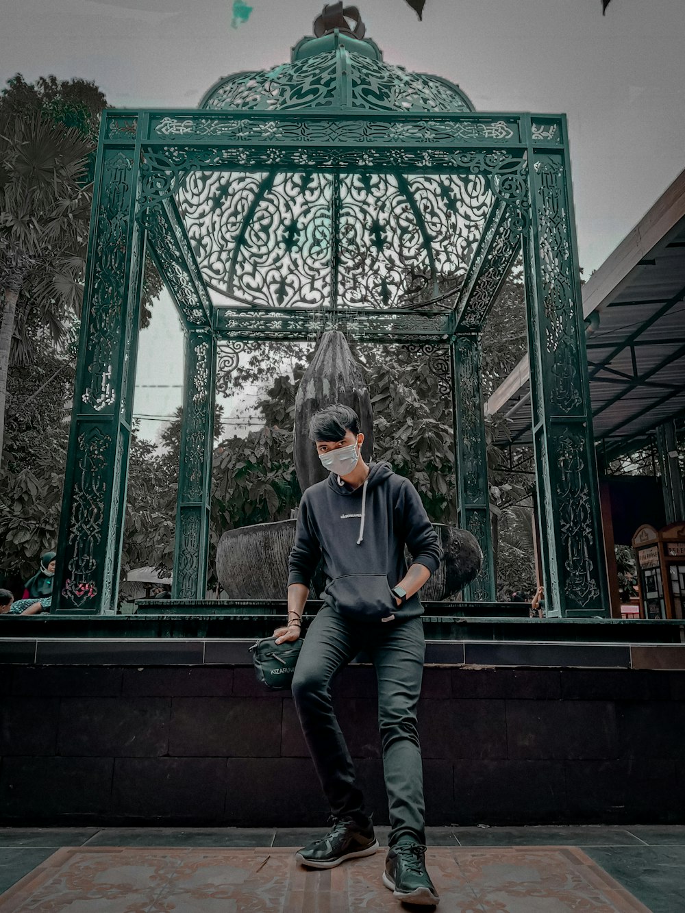 man in gray long sleeve shirt and blue denim jeans sitting on brown wooden bench