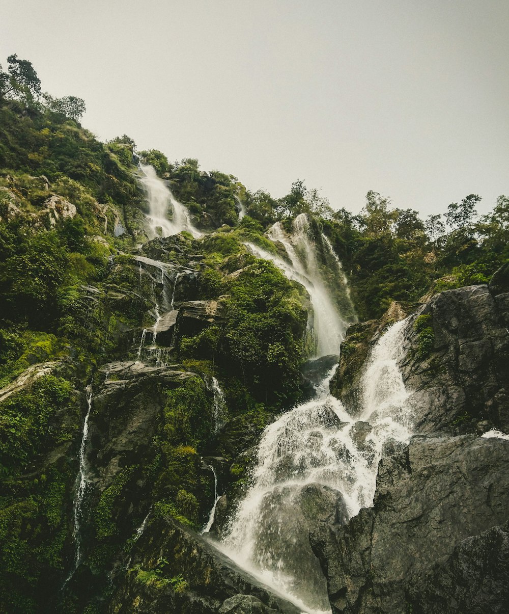 waterfalls on rocky mountain during daytime