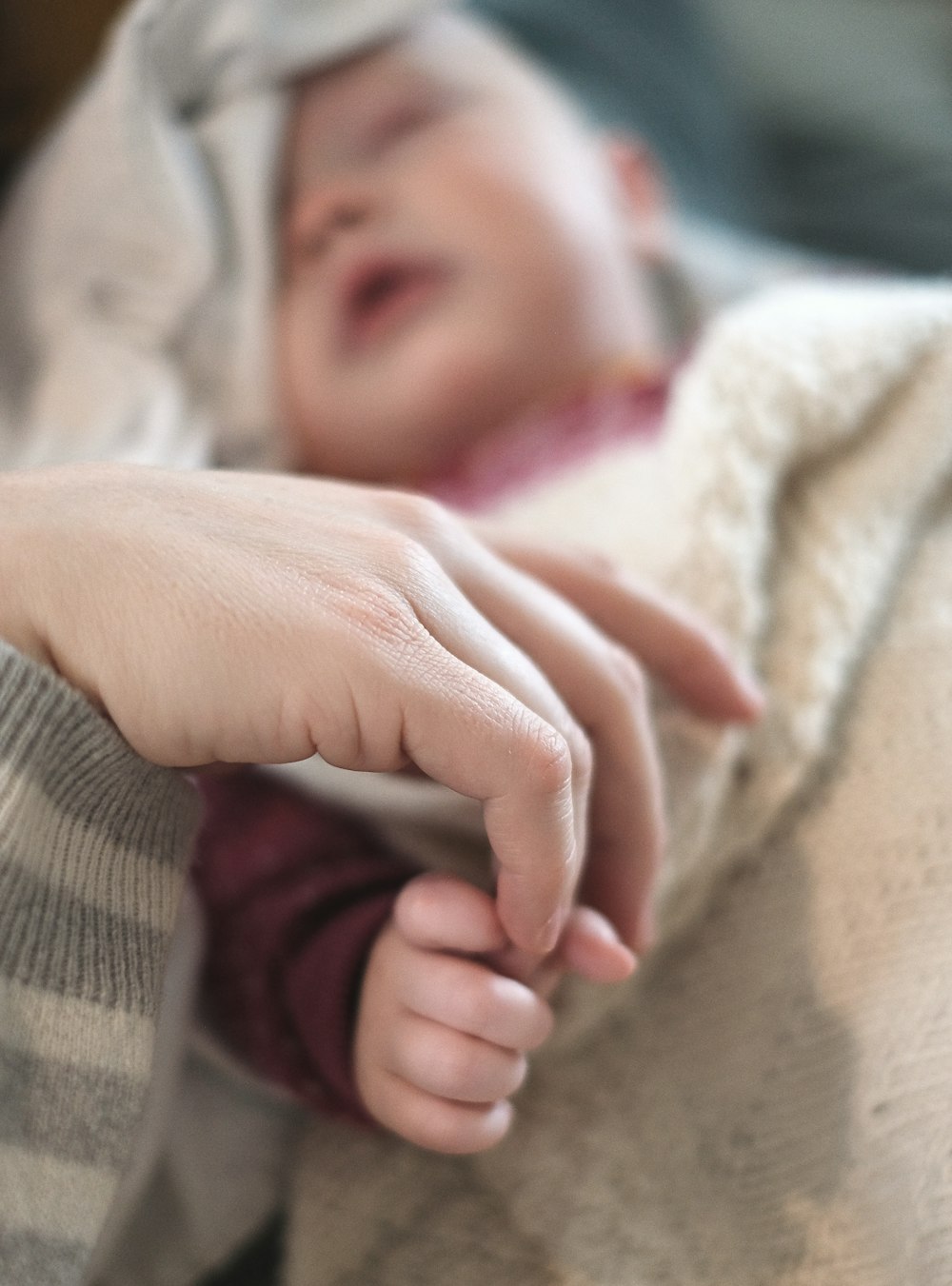 babys hand on white textile