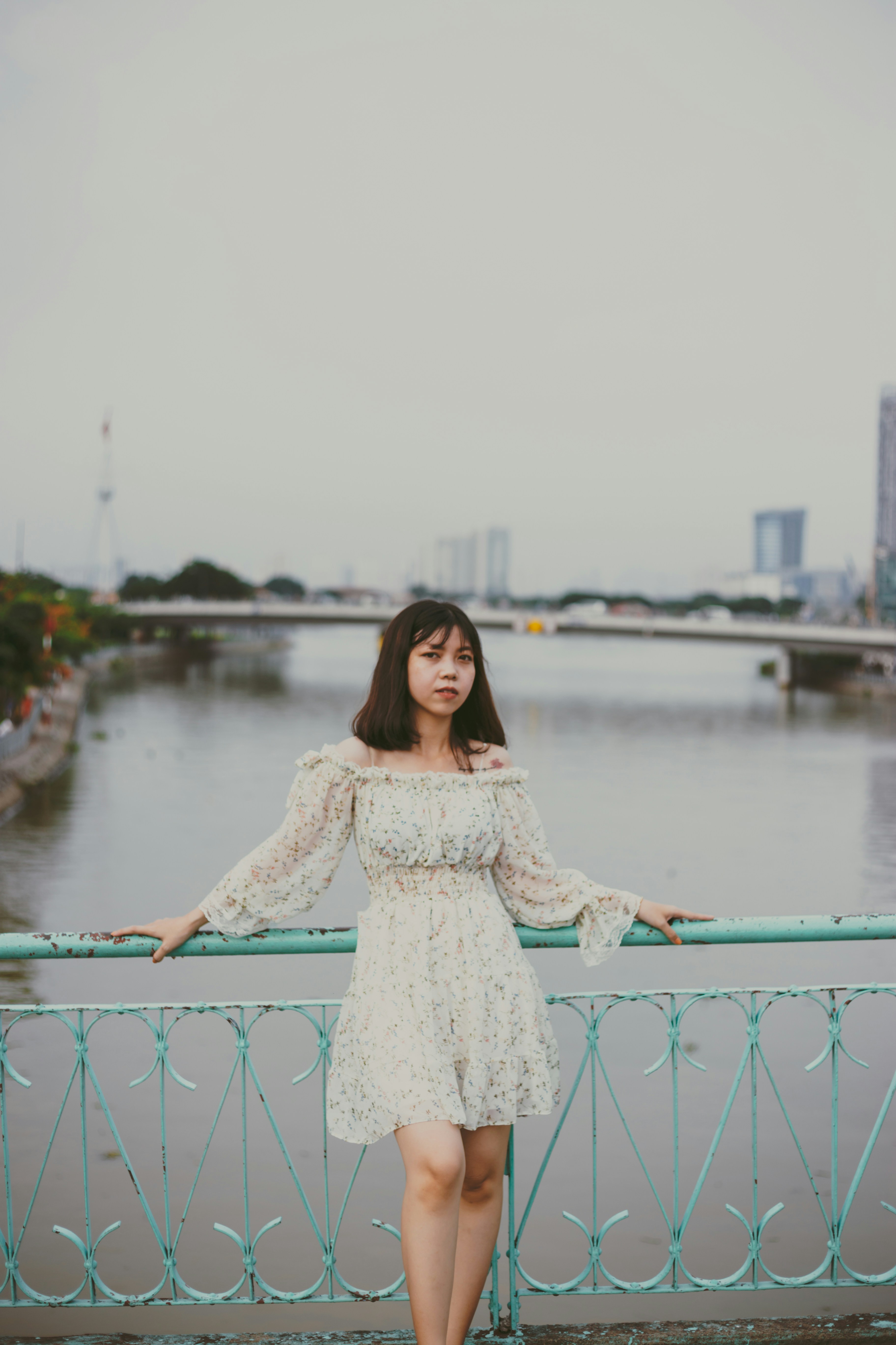 Woman in white dress standing on blue metal railings photo – Free Human ...