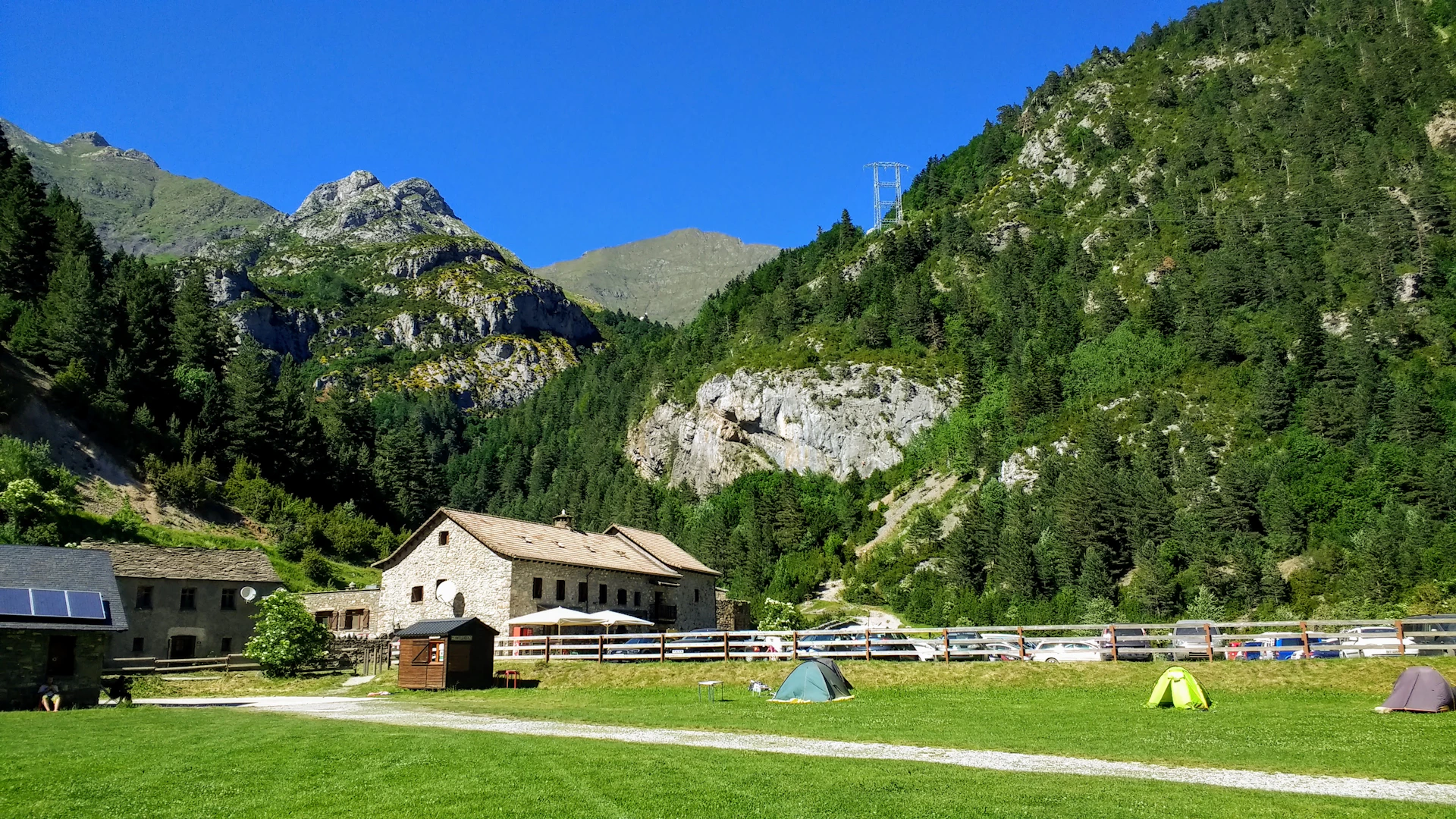 brown wooden house near green trees and mountain during daytime