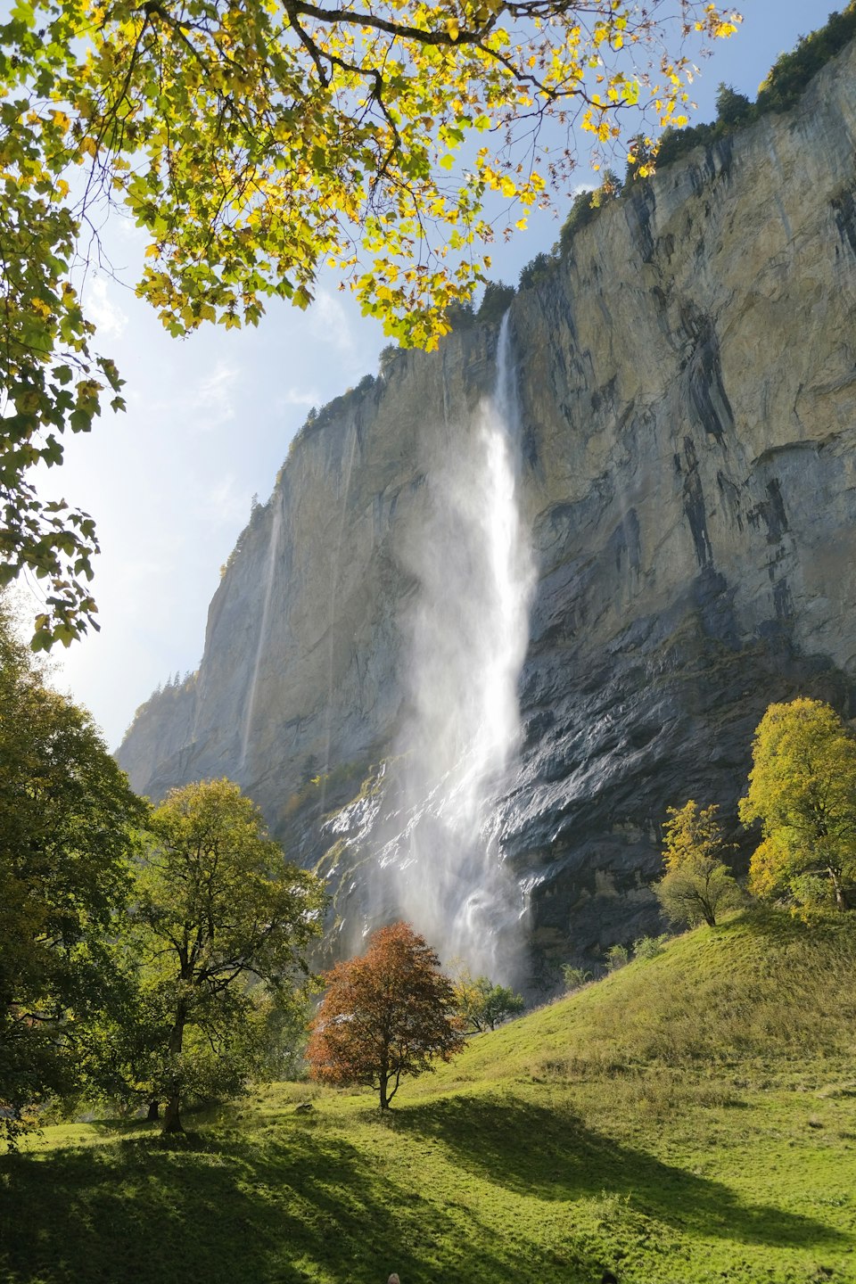 Staubbach Falls plunging down a sheer cliff face into the green Lauterbrunnen valley