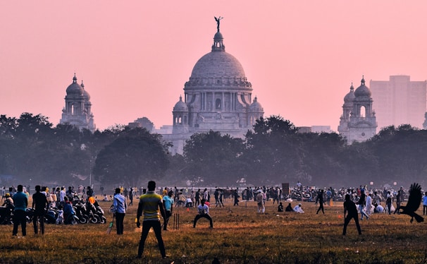 A panoramic view of a sports ground bustling with cricket and football activities.