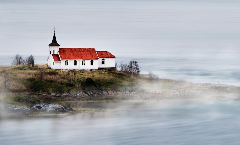 white and red house near body of water