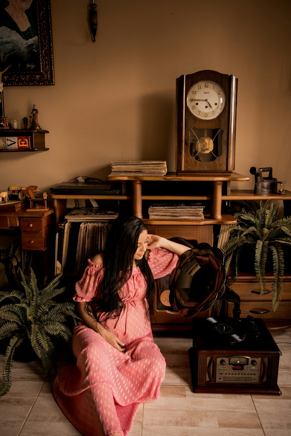 woman in pink dress sitting on brown wooden table