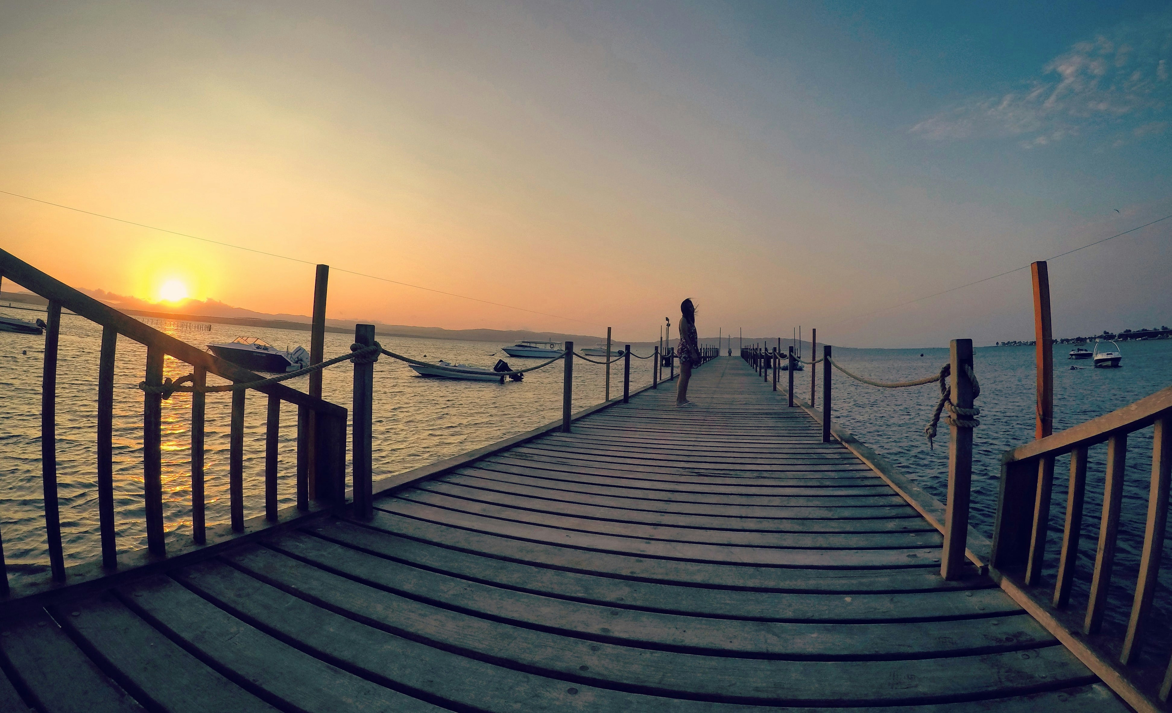 person walking on wooden dock during daytime