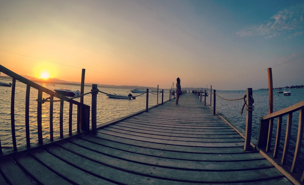 person walking on wooden dock during daytime