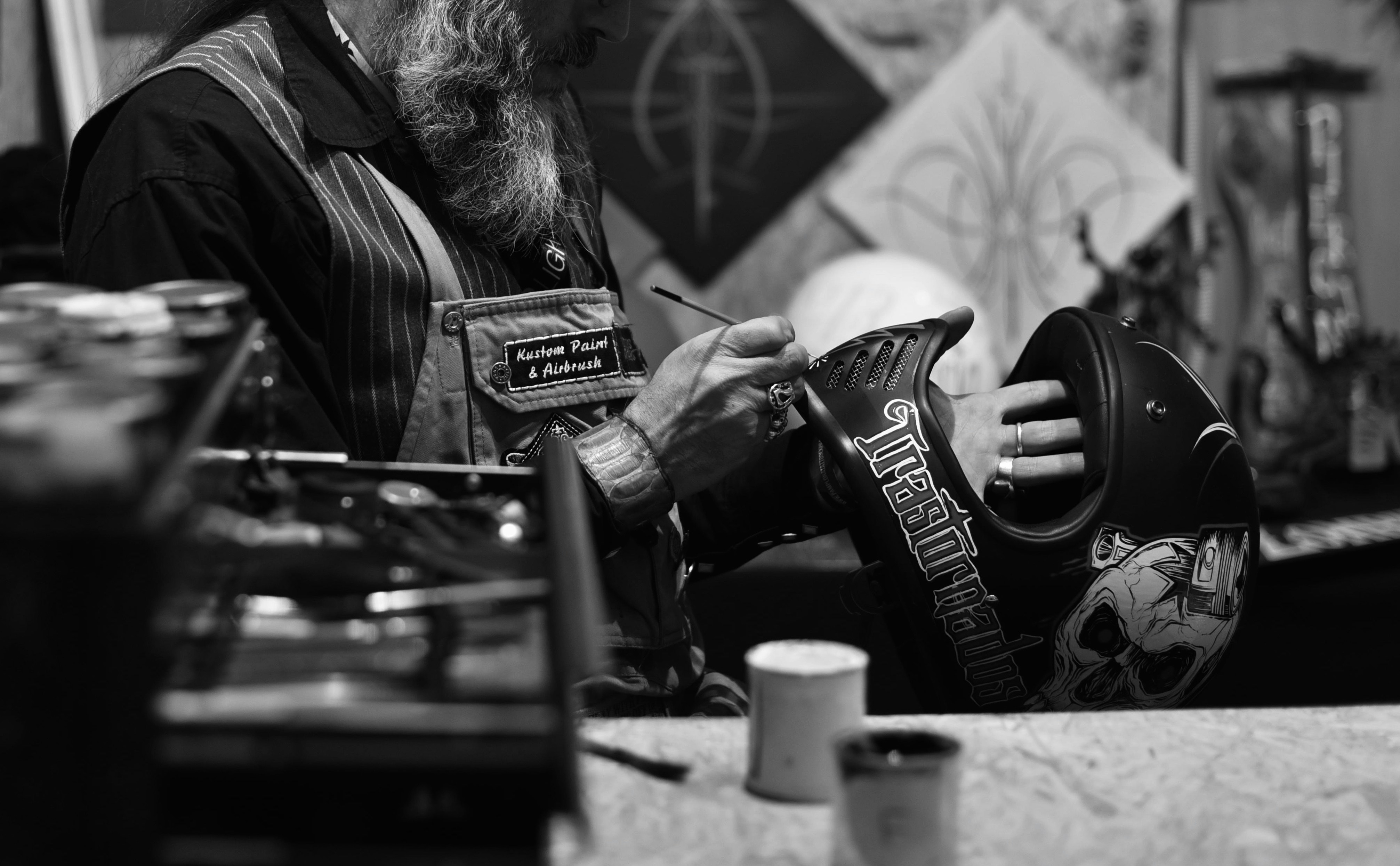 man in black leather jacket holding black and white ceramic mug