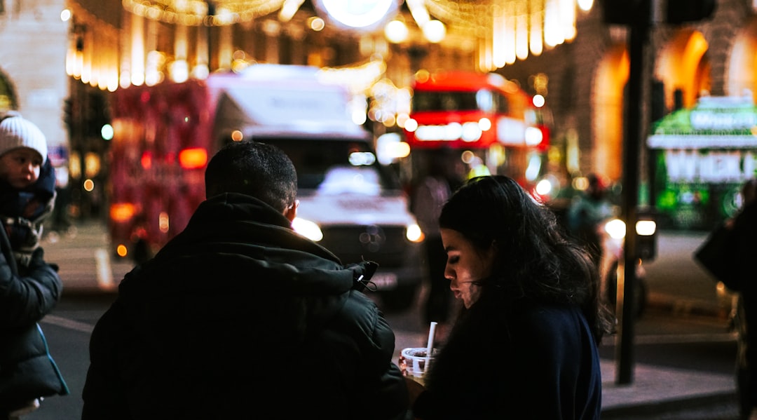 man and woman standing in the street during night time