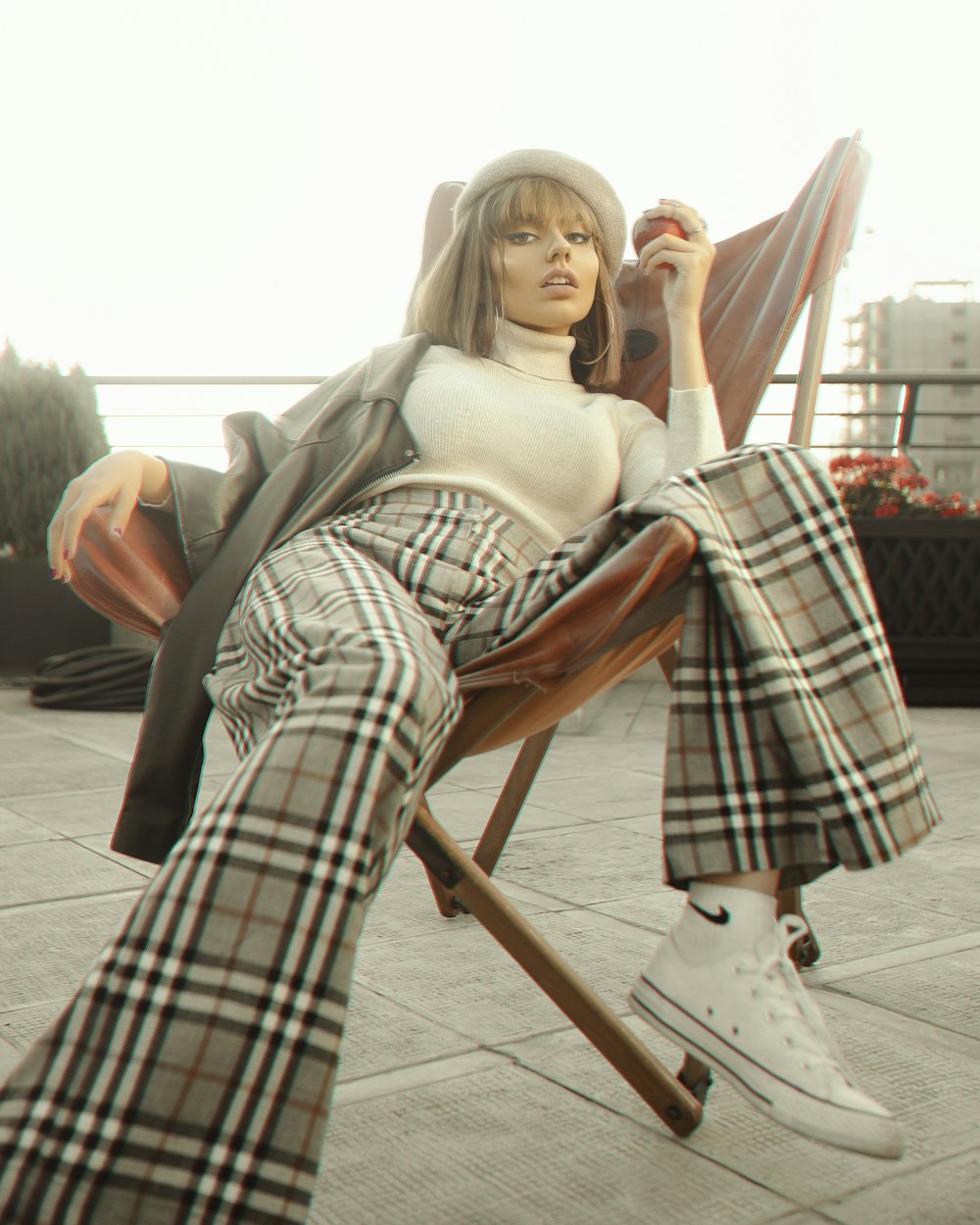 woman in gray scarf sitting on brown wooden folding chair