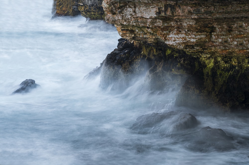 ocean waves crashing on rocky shore during daytime