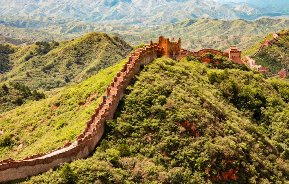 brown brick bridge on green grass field near mountain during daytime