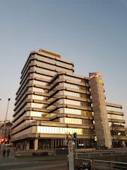 A contemporary office building with sharp angles and ambient evening lighting.