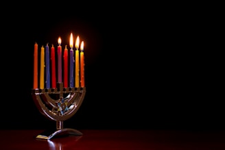 A beautifully arranged menorah glowing warmly on a wooden table.
