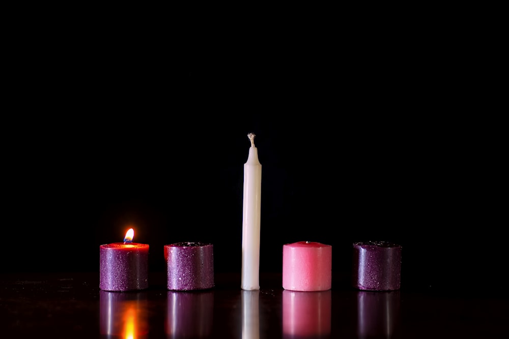 pink candles on black surface