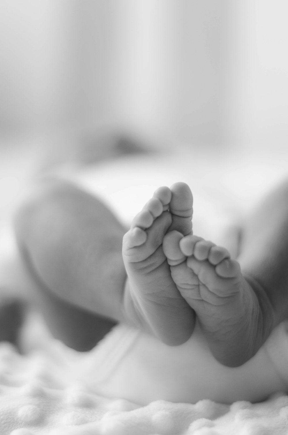 Foto en escala de grises de los pies del bebé