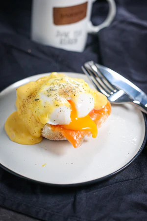 Eggs Benedict with poached eggs and hollandaise on English muffins
