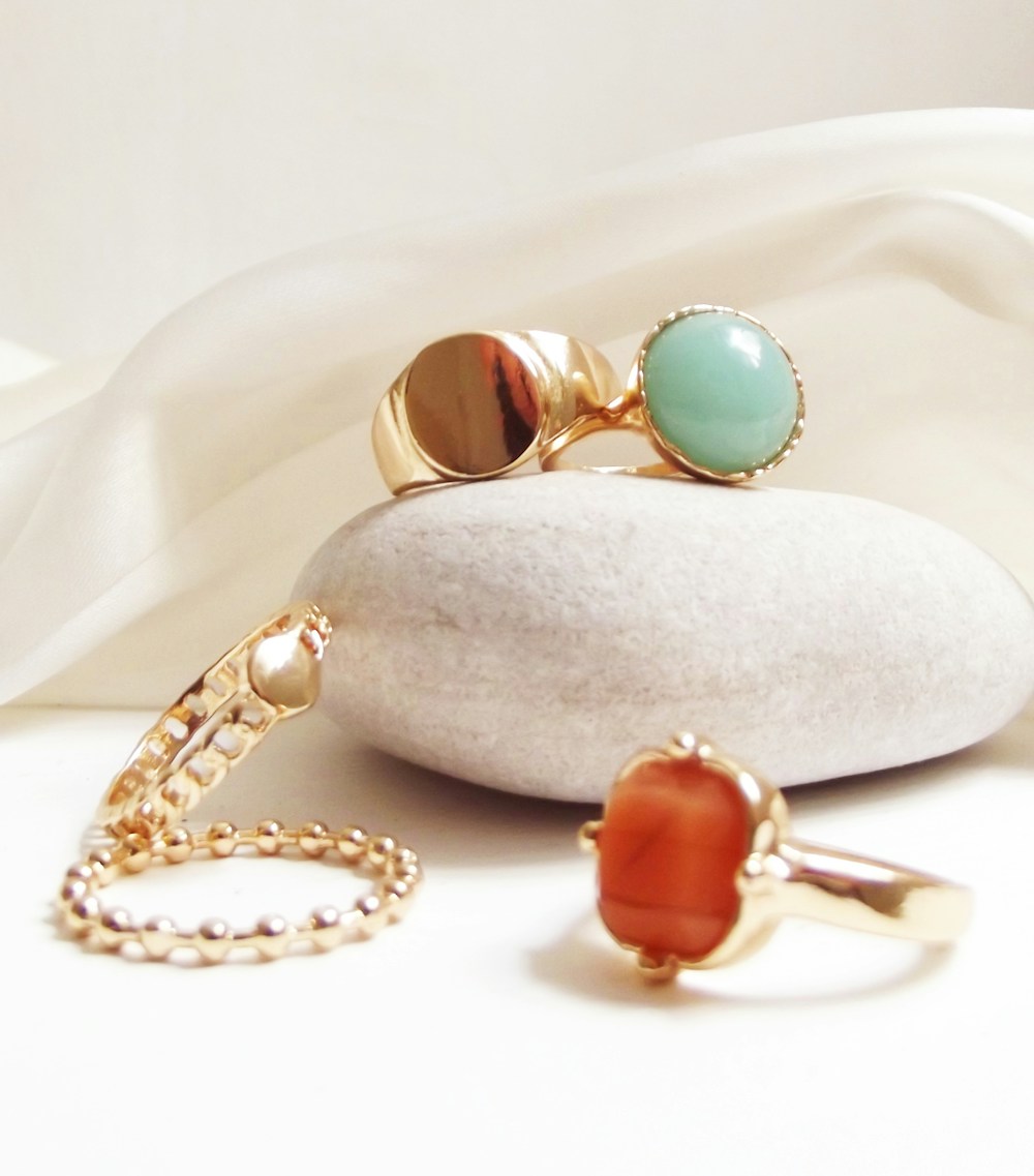 Solid gold rings and a fine bead chain laid out on ivory silk before sizing