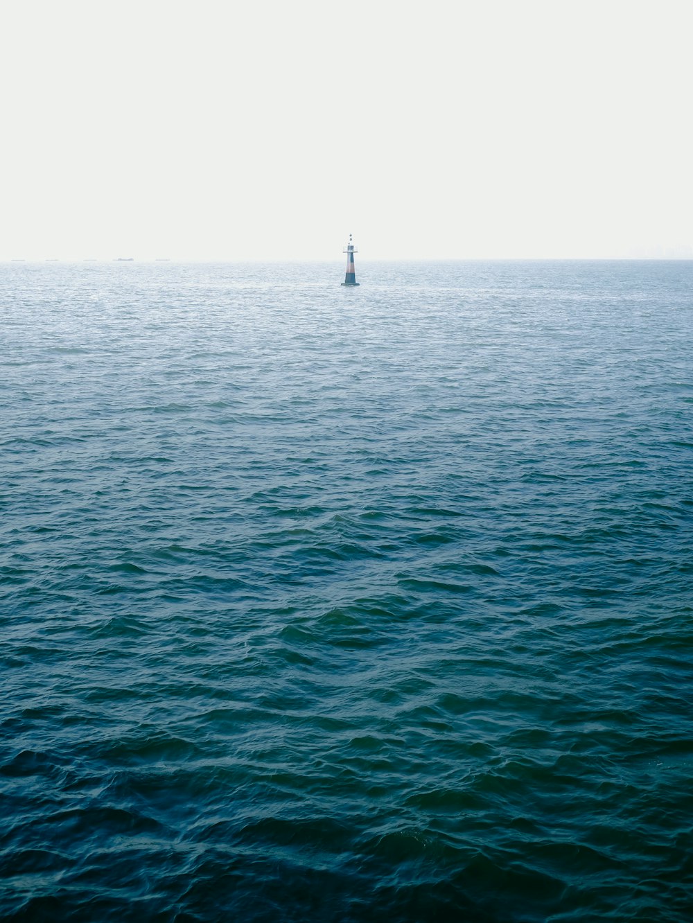 body of water under white sky during daytime