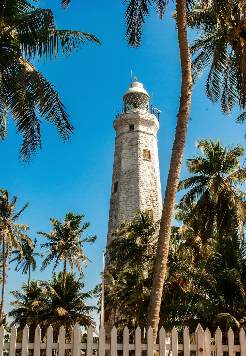 weißer und brauner Leuchtturm unter blauem Himmel tagsüber