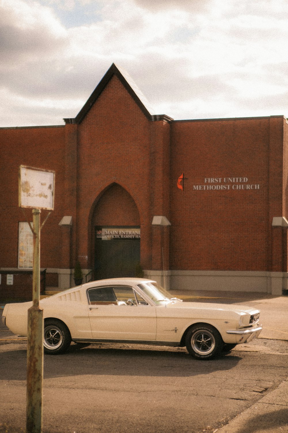 white coupe parked beside brown building