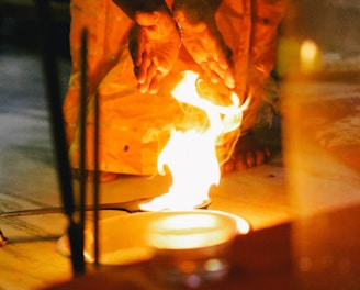 man in brown leather jacket holding a stick with fire