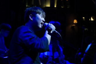 Yasmin Dream performing passionately on stage under soft blue lights.