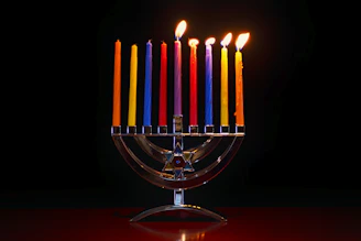 A radiant 7-branch menorah glowing warmly against a dark background, symbolizing faith and light.