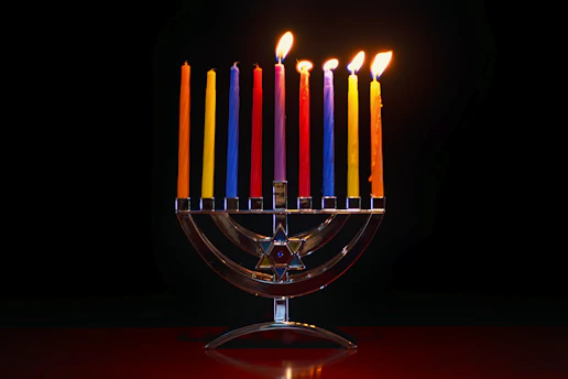 A radiant 7-branch menorah glowing warmly against a dark background, symbolizing faith and light.