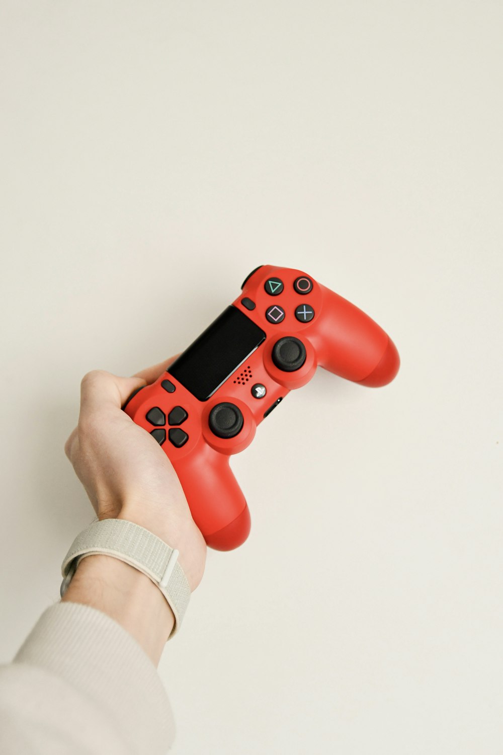 person holding red sony ps 4 controller