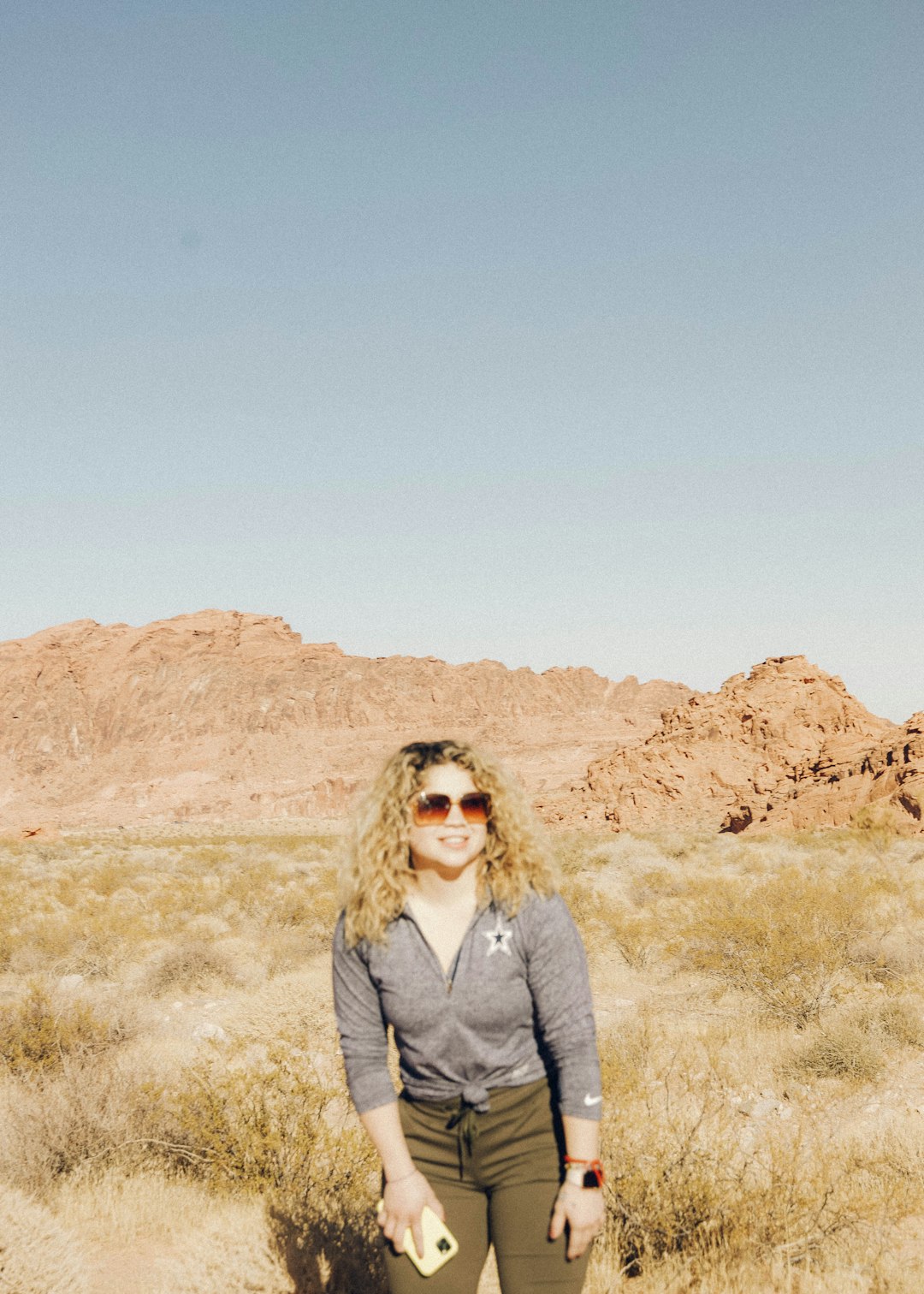 woman in gray jacket standing on brown grass field during daytime