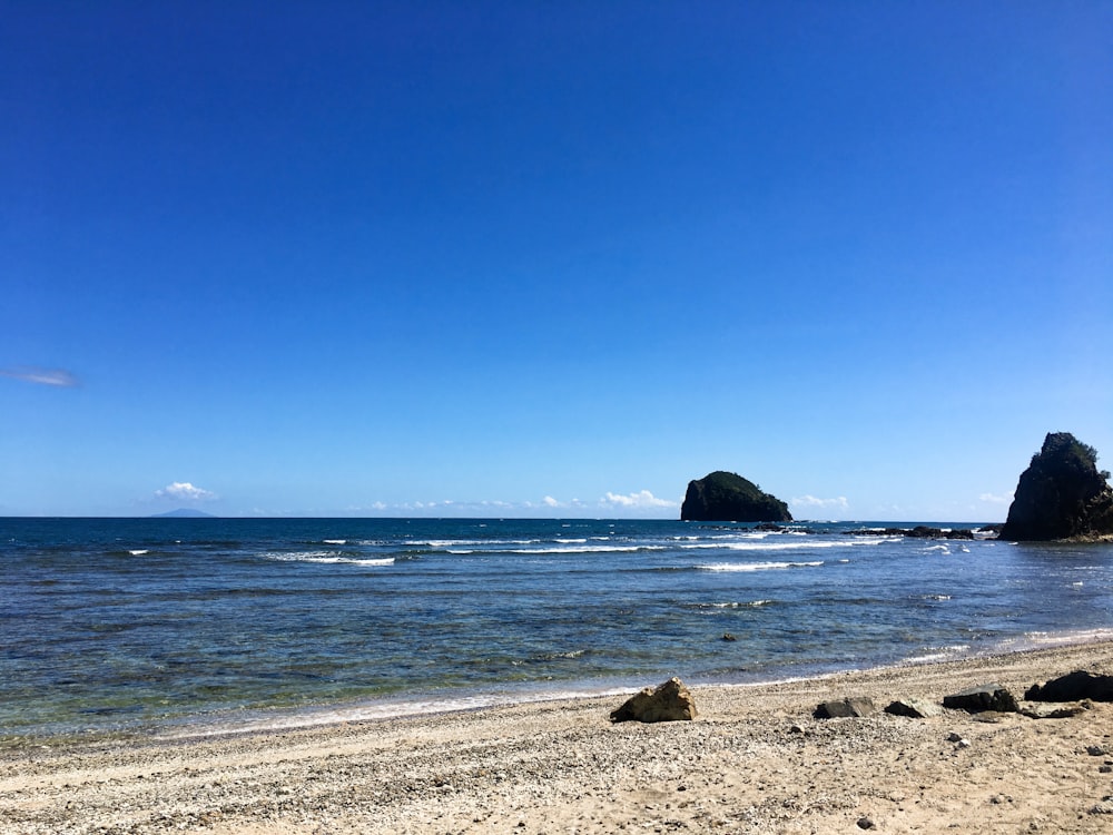 brown rock formation on sea shore during daytime