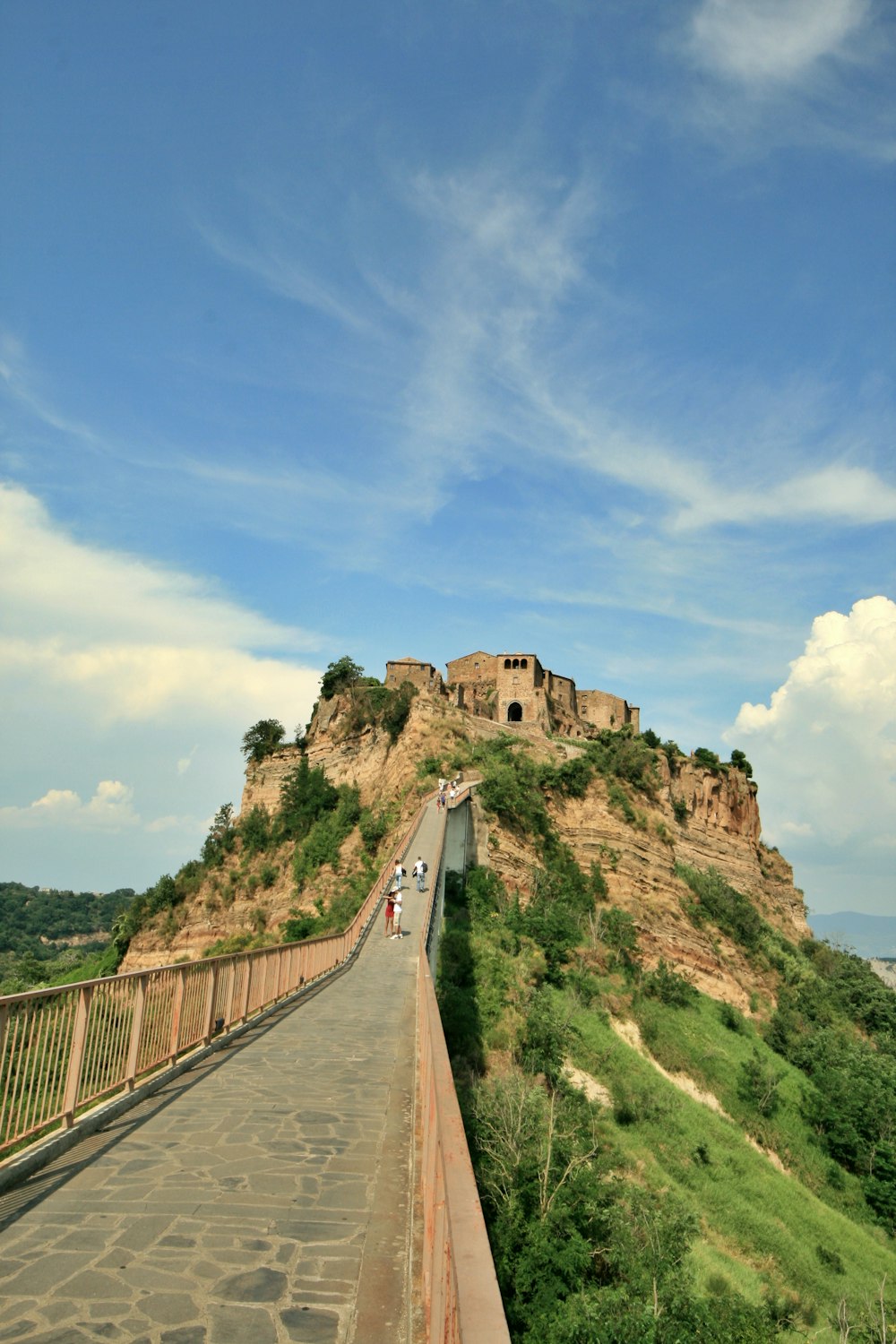 brown wooden bridge on top of green mountain during daytime