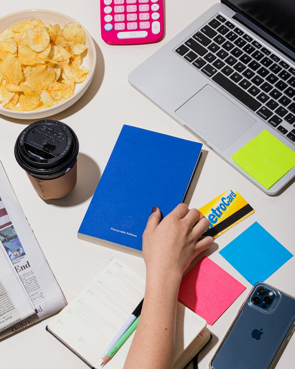 person holding blue sticky note beside macbook pro