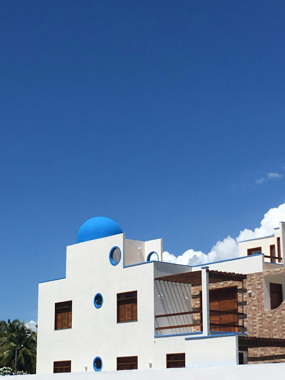 Edificio de hormigón azul y blanco bajo el cielo azul durante el día