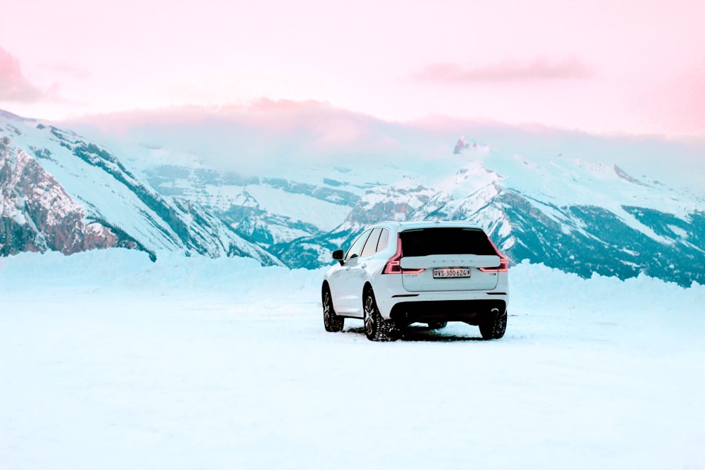 昼間の雪原を走る白いSUV