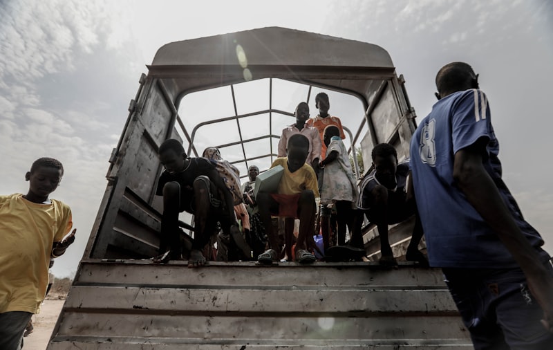 Displaced people boarding a truck during a humanitarian crisis