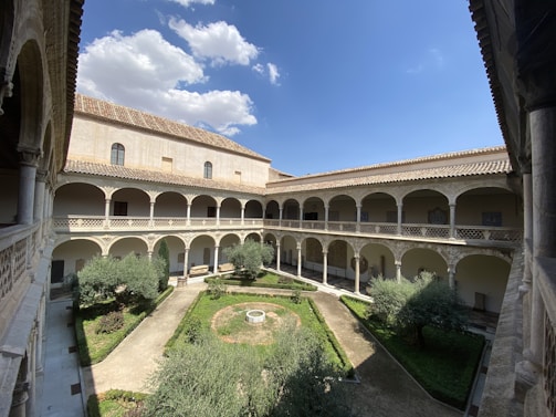 A peaceful courtyard garden with gentle greenery and soft blue skies above Deva Towers.