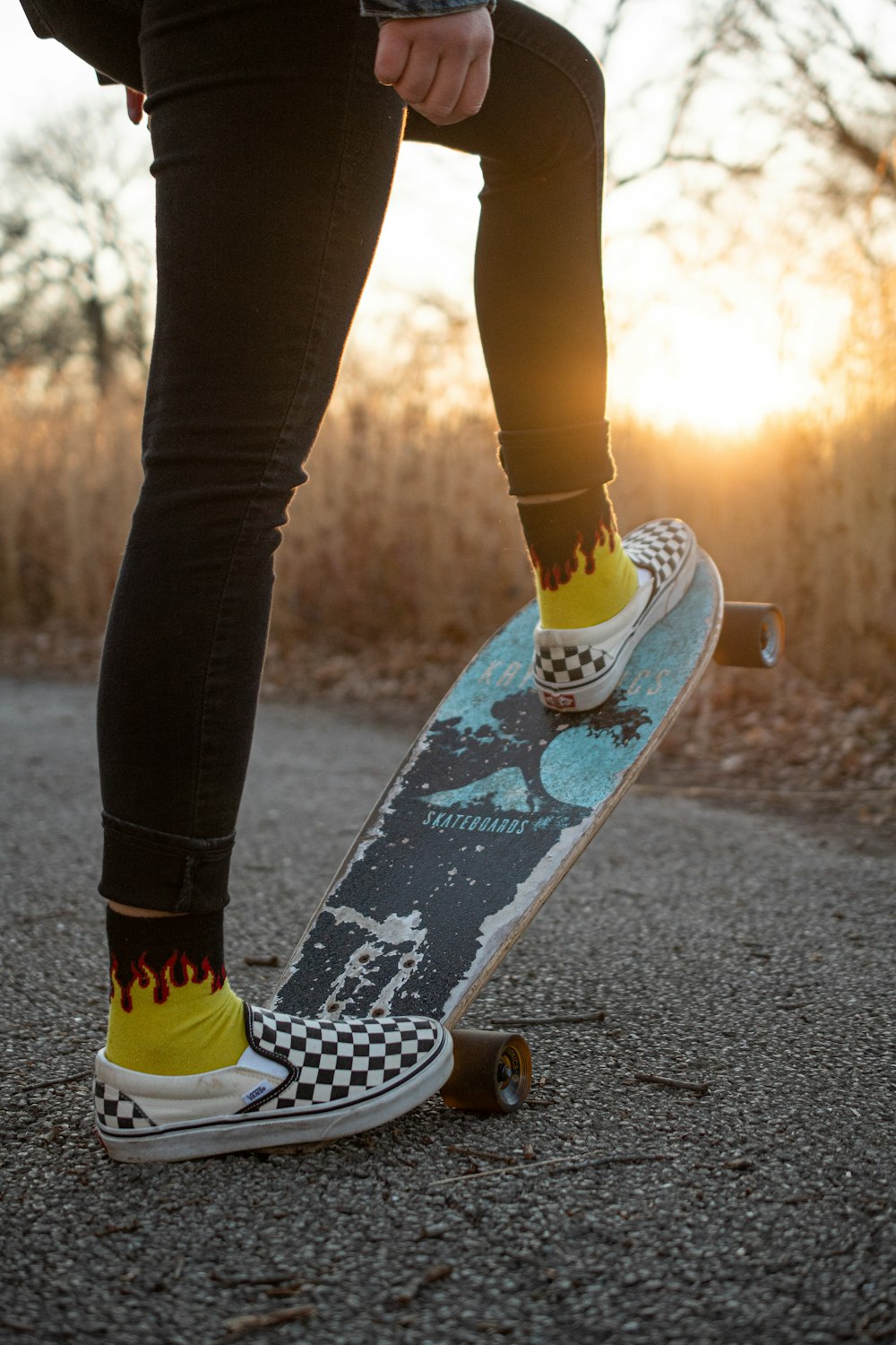 Persona in jeans blu denim e scarpe da ginnastica Nike bianche in piedi sulla strada di cemento grigia durante il giorno