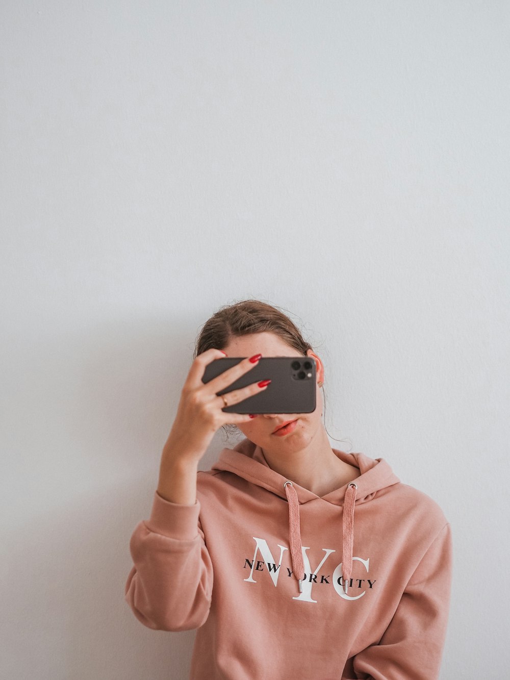 woman in pink hoodie wearing black sunglasses