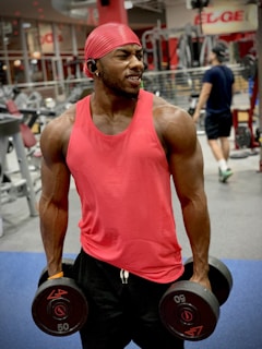 A smiling person lifting weights during a personalized training session at rdnutfit gym