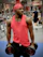 A smiling, fit young man lifting weights in a sleek, modern gym with bold black and red accents.