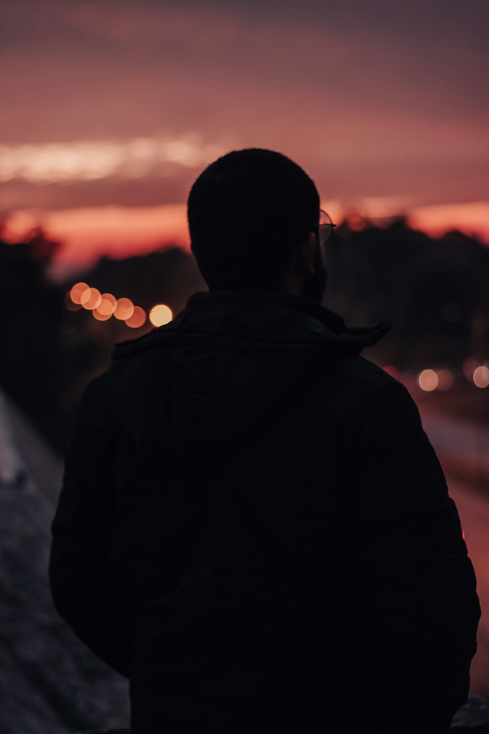 man in black jacket standing during sunset