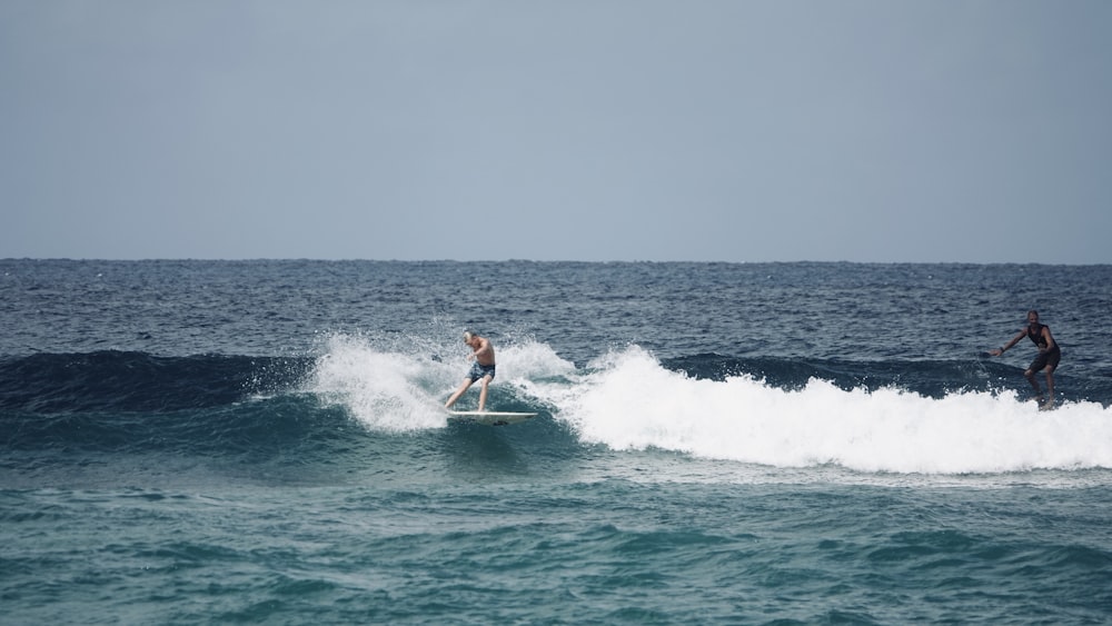 man in red shirt surfing on sea during daytime