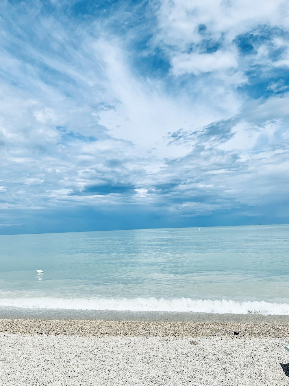 mar azul bajo el cielo azul y nubes blancas durante el día