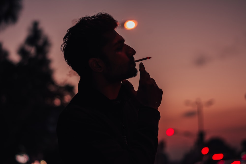 man smoking cigarette during night time